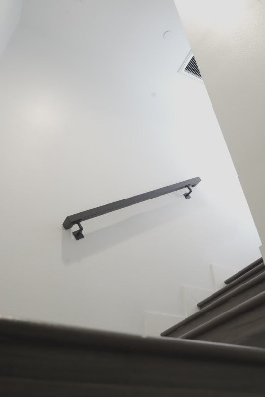 Looking up from bottom flight of stairs at the 1.5"x1.5" Metal Handrail at a second flight of steps